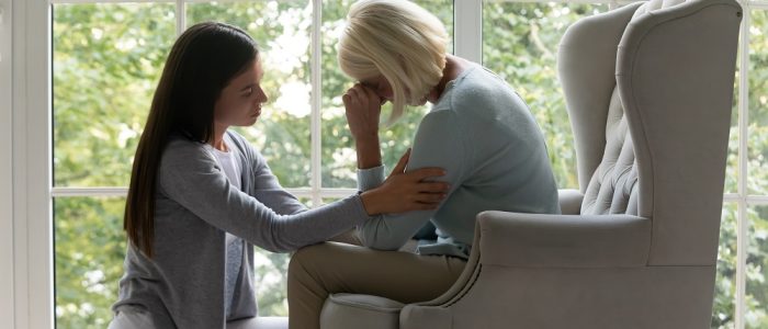 Daughter comforting elderly mother sharing difficult life period giving support